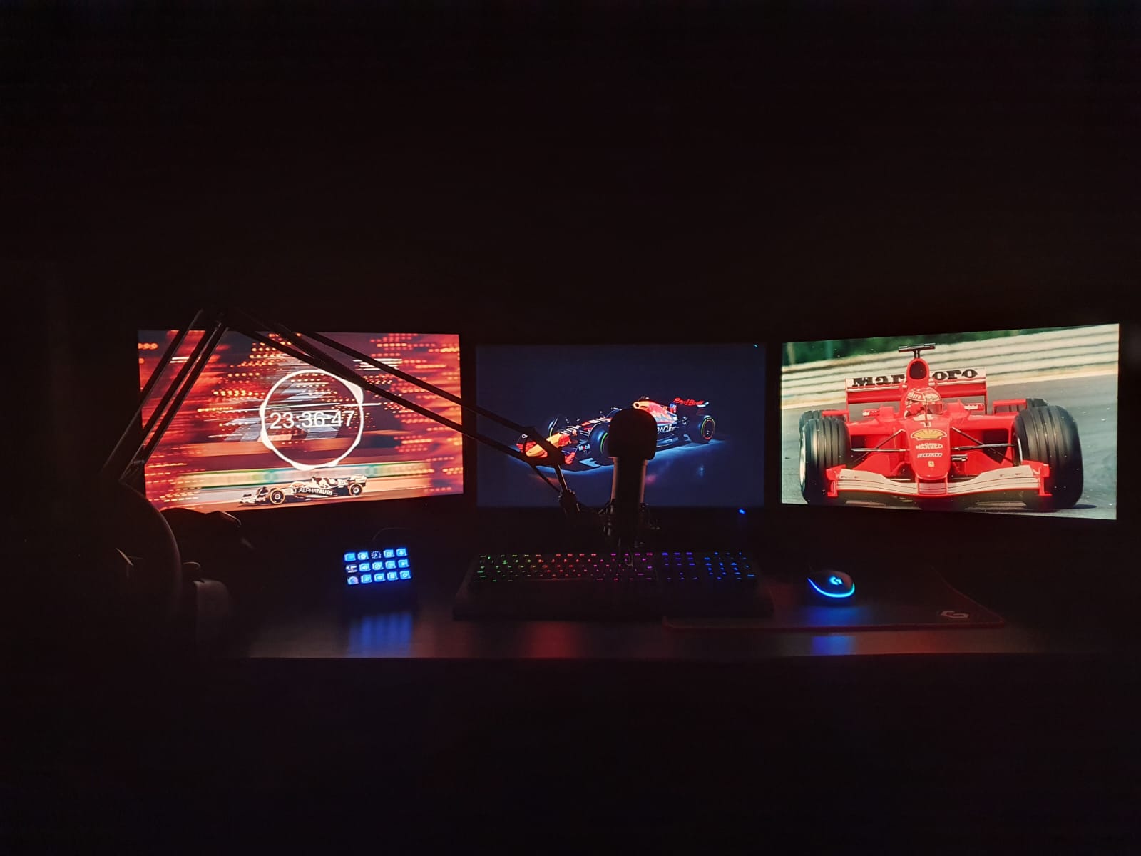 Computer met 3 schermen, muis, toetsenbord en een stuur